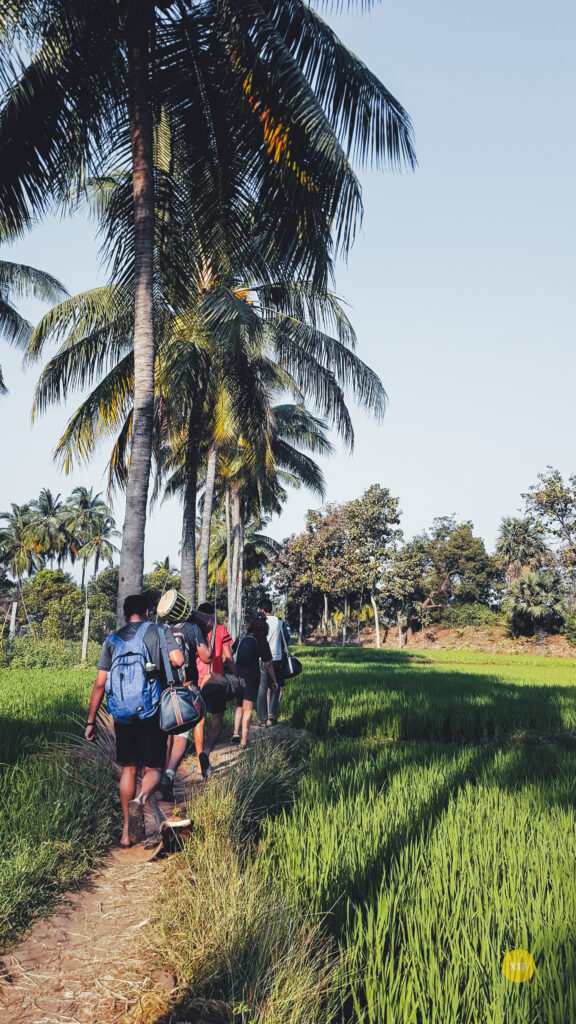 People walking through rice paddies of Hampi Hippie Island