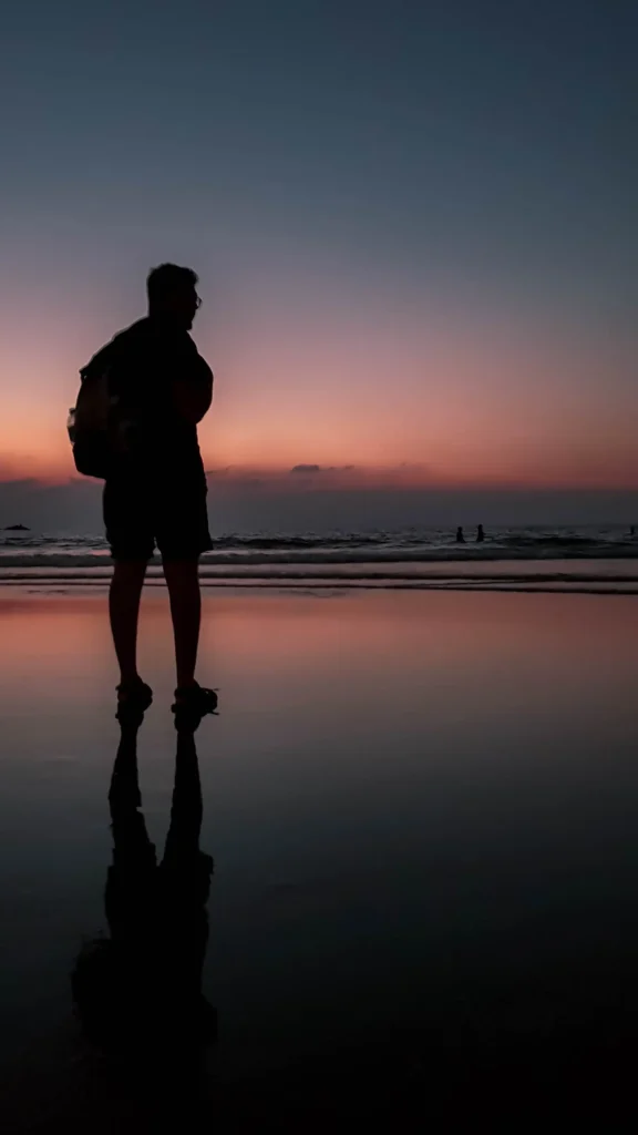 a person standing on a beach of gokarna at sunset while doing the beach trek