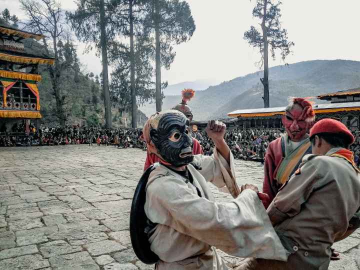 Atsara funnily beating a police in Paro Tshechu festival