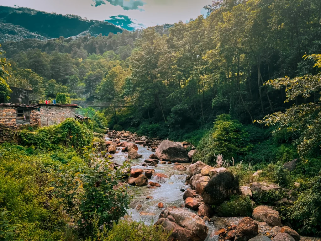 Annapurna Base Camp Trek (ABC) – (Xplore The Earth): River flowing through a village on the trail