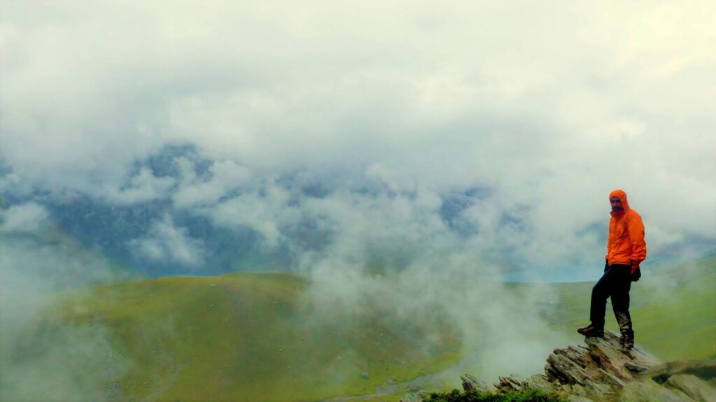 Trekker Posing for the Camera in a Meadow with the Mist All Around - How Difficult is the Kashmir Great Lakes Trek?