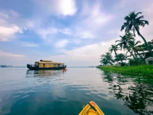 kayaking in backwaters of alleppey with a houseboat in front