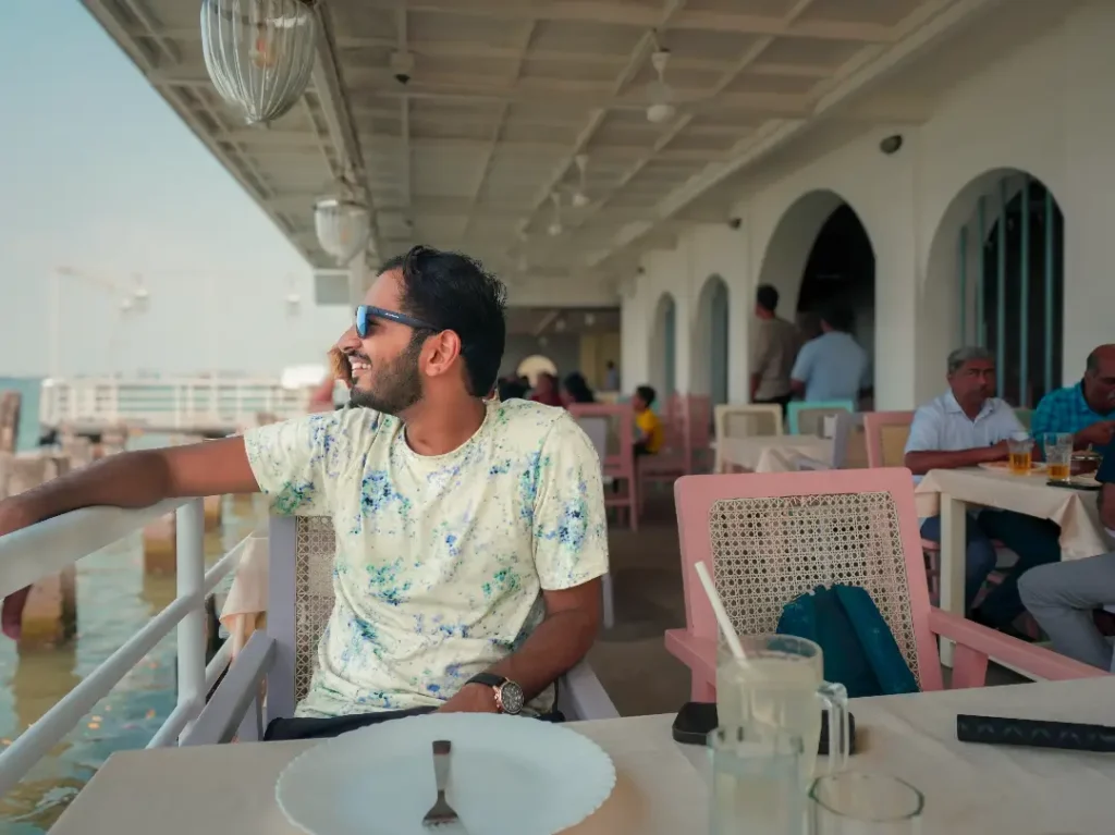 a person sitting by the sea at seagull restaurant in fort kochi