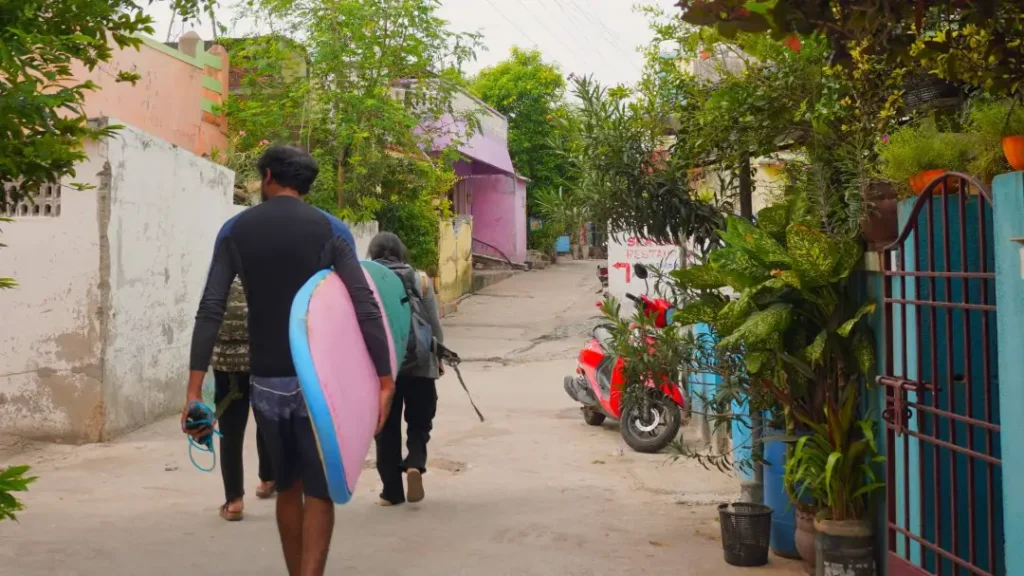 walking streets of mahabalipuram with a surf board